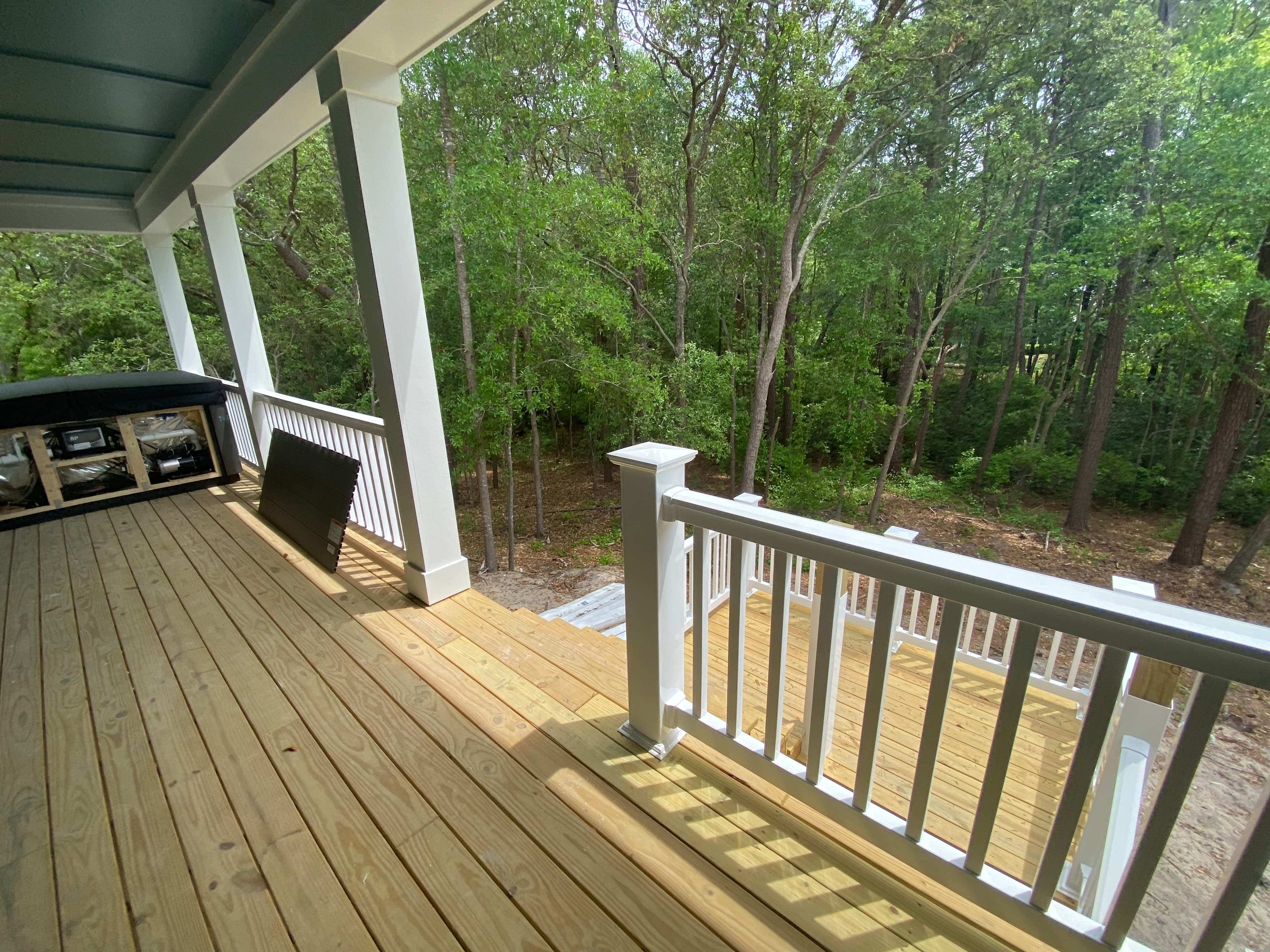 Wood deck white columns wooded backdrop